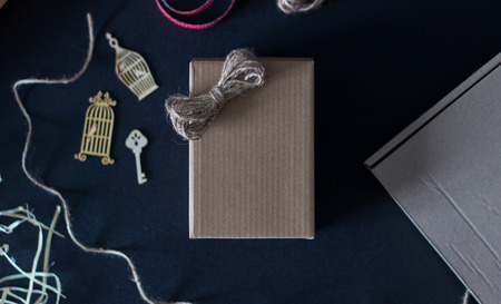 Craft paper gift box on dark background. Flat lay style, top view.