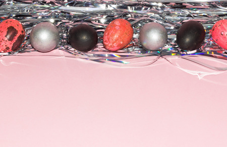 Easter eggs. Pink, silver and black colored eggs with pink background. Easter wallpaper. Copy space.の写真素材