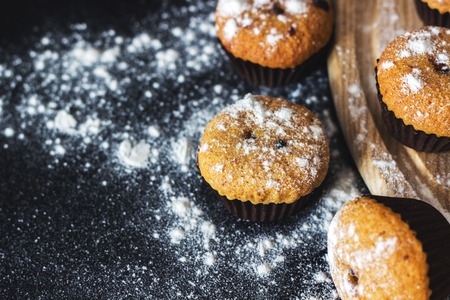 Homemade cupcakes with sugar powder on a blackの写真素材