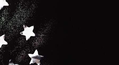 Silver stars and sparkles on black background. Flat lay, copy space.の写真素材
