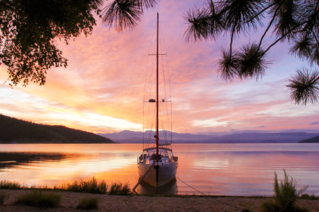 Silhouette of a yacht with a lowered ladder on Lake Baikal at dawn. The concept of ecological travel and tourism.の写真素材