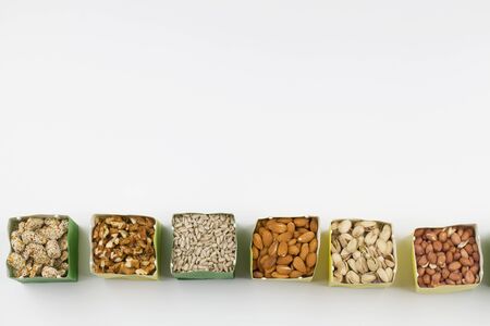 Eco-friendly packing. Paper bags with pistachios, sunflower seeds, walnuts, cashew, peanut ,almond, pine nuts . zero waste shopping sustainable living plasticfree. Top view. Flat layの写真素材