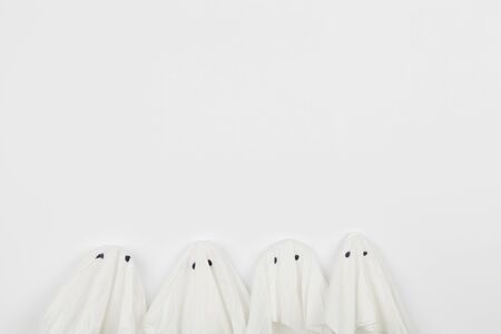 Top view of Halloween crafts, paper ghost on orange paper background with copy space for text. halloween concept.の写真素材