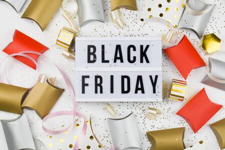 Black friday sale text on white lightbox, golden stars, holiday ribbon and packaging around on white background. Template Black friday sale mockup fall thanksgiving promotion advertisingの写真素材