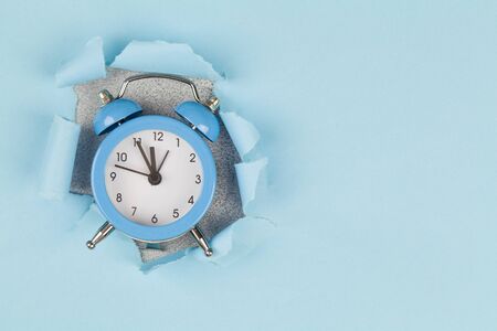 Time concept. alarm clock through hole in pink paper background. Wake up alert concept. violet Alarm...