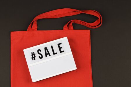 Eco red natural bag and lightbox with text sale on black background.