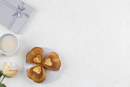 rcupcakes shaped heart, decoration , gift, tea and flowers on white background. Valentines day background. love symbol, space for text concept. graphic design element for greeting cards, banners, saleの写真素材