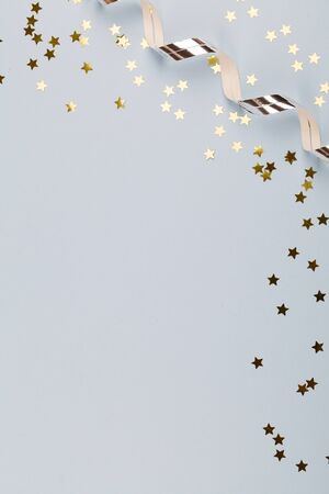 Festive party border or frame of silver spiral streamers and confetti on blue background, copy space top view flat lay close upの写真素材