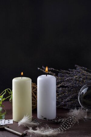 Divination with white candles, lavender, fortune-telling ball, cards and key. Halloween background, occult and esoteric objects on witch wooden tableの写真素材