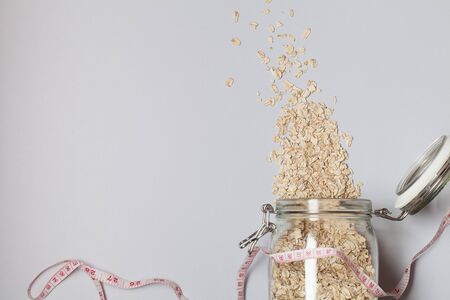 Natural oatmeal and measurement on gray background . Oatmeal in a glass pot.healthy breakfast concept . top view flat lay copy spaceの写真素材