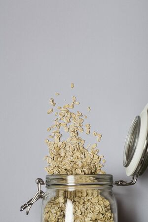 Natural oatmeal on gray background . Oatmeal in a glass pot.healthy breakfast concept . top view flat lay copy spaceの写真素材