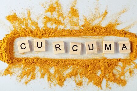 text curcuma and turmeric powder on gray background, indian spice, healthy seasoning ingredient for vegan cuisineの写真素材