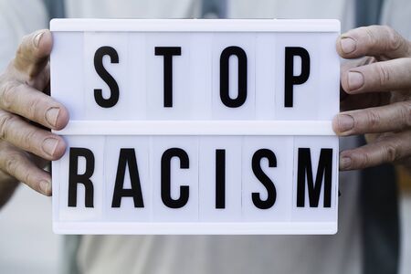 old man holding light box with STOP RACISM messageの写真素材