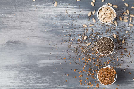 Healthy superfood sunflower seeds, flax seeds and chia on blue wooden background copy spaceの写真素材