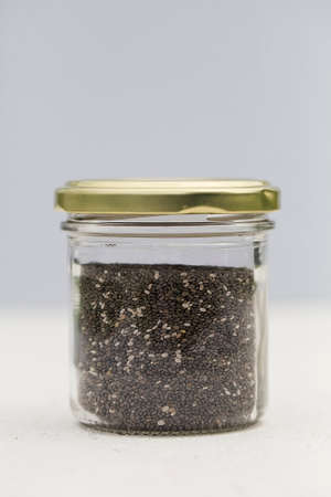organic chia seeds in glass jar on gray background. Concept of healthy diet. Super food. selective focus copy spaceの写真素材