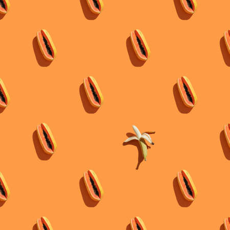 Trendy sunlight Summer pattern made with papaya and banana on bright light orange background. Minimal summer concept. squareの写真素材