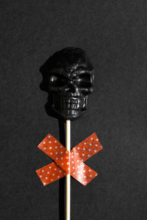 black lollipop in form of skull on black background. Creative Halloween minimal concept. flat lay top viewの写真素材