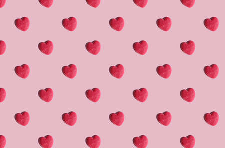 pattern made with red heart on pink background. flat lay. minimal love concept.