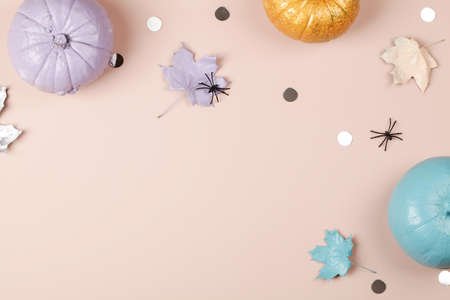 Halloween flat lay with blue purple and gold pumpkins on pink background. Holiday greeting card, invitation concept. copy space top viewの写真素材