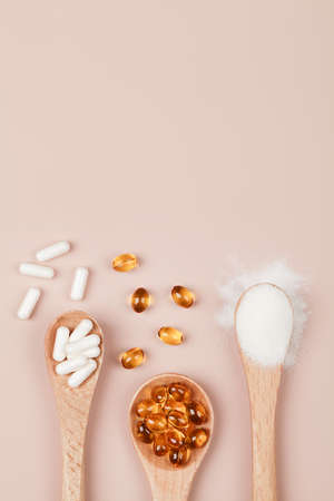 Supplements for health, vitamin D zinc and vitamin C powder in wooden spoons on beige background. copy space top view .healthy lifestyle concept.の写真素材