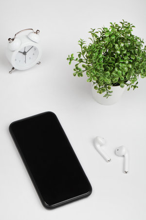 Working table with smart phone, flower, clock and headphone. Top view. flat lay copy space