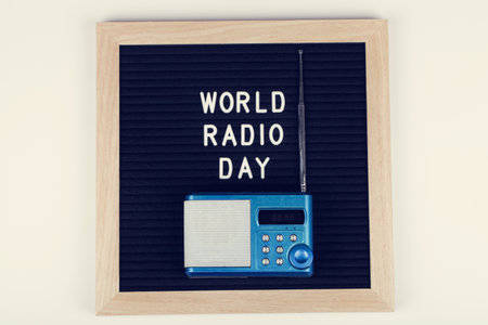 black letter board with text world radio day with blue radio on white background. Top view. flat lay minimal background.の写真素材