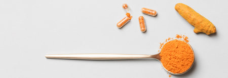 health care lifestyle concept. spoon with turmeric powder, root and pills on blue background. flat...
