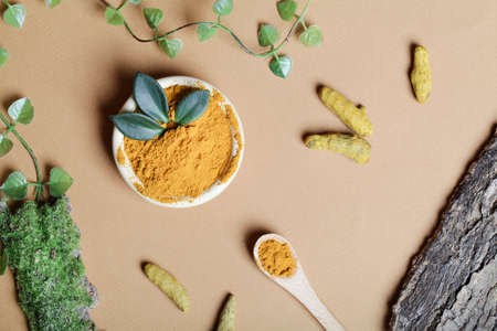 health care lifestyle concept. Curcuma Longa or turmeric powder in bowl with green leaf,wooden spoon...