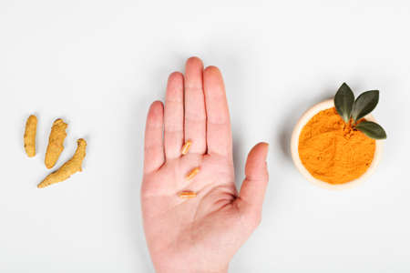 health care lifestyle concept. Curcuma Longa or turmeric powder in bowl with green leaf, root and...