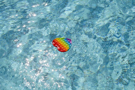colorful antistress sensory popping toy in form of heart in blue water. summer and relax concept....