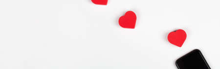 Red hearts and two mobile phones on white background. Internet dating, copy space, Valentines day concept. bannerの写真素材