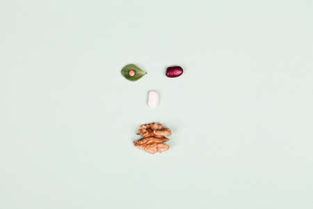 healthy eating . Top view of beans and nut in form of face on green background. Vegan raw diet concept. copy spaceの写真素材