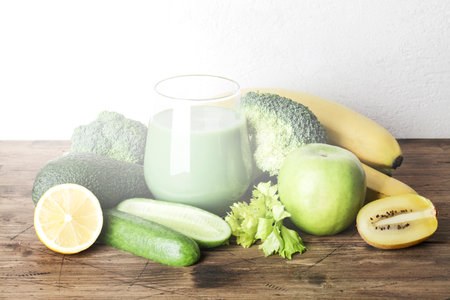 fresh green smoothie in glass with vegetables on wooden and white background. vegan food, self care and healthy lifestyle.Healthy detox dietの写真素材