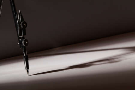 Compass is geometric tool on dark background. crisis and hardship, conflict,metaphor concept. risk...