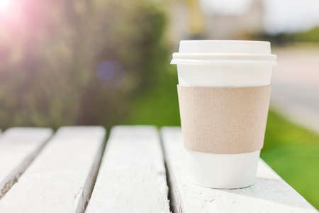 Mockup of take away disposable paper coffee container or cup on street. minimal, ecology, lifestyle concept. selective focus copy spaceの写真素材