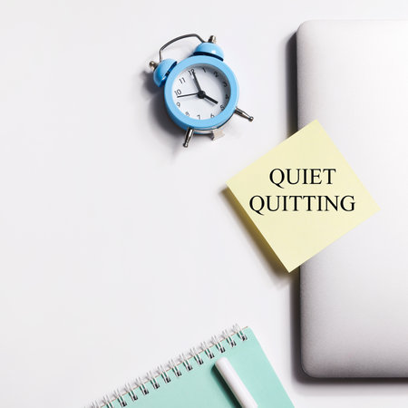 quote 'Quiet quitting' on yellow sticker on computer with clock and notebook. work life balance concept. post covid life philosophy. squareの写真素材