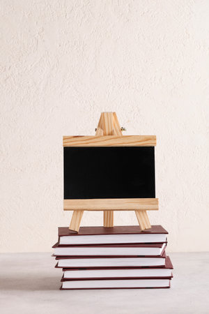 black board for text on stack of books on white background. copyspace. Education and exhibitions, meetings concept. back to schoolの写真素材