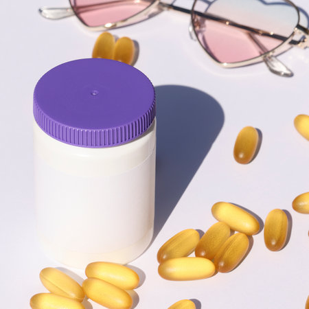 white plastic bottle with pills and sunglasses on white background. template, mock up concept....