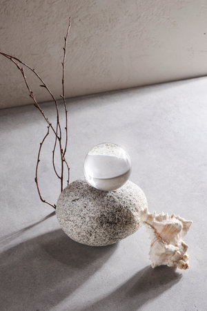 stone, transparent ball and seashell on gray background. still life, abstract organic design concept. calm and relax style. photo for interior.の写真素材
