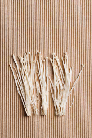 white enoki mushrooms on brown background. Natural medicine, reduce stress and improve immunity ,...