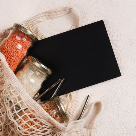 Zero waste lifestyle concept.Responsible consumption, healthy vegetarian food. black board for text and mesh , glass jar with food, reusable strawsの写真素材