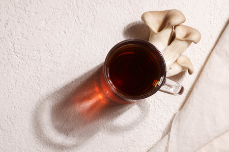Natural medicine, reduce stress and improve immunity concept. Mushroom hot drink. Tea in glass mug with mushrooms on white background. copyspace.の写真素材