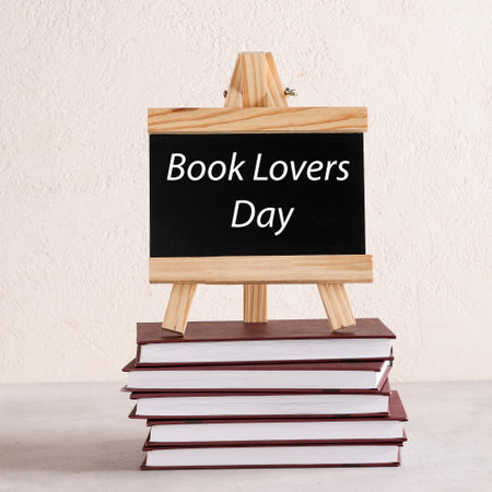 Book Lovers Day written on black board on stack of books on white background. book holiday, education concept. squareの写真素材