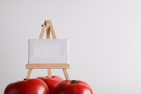 red ripe tomato and white board for your text on white background. Home vegetable, harvest on organic farm. Ingredients, recipes, cooking book conceptの写真素材