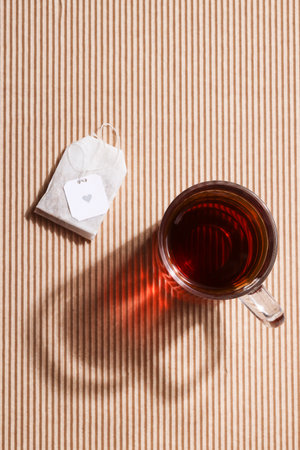 Cup of tea on brown ribbed background with beautiful shadow and tea bag.traditional and cultural concept. healthy lifestyle.copy space. relax tea timeの写真素材