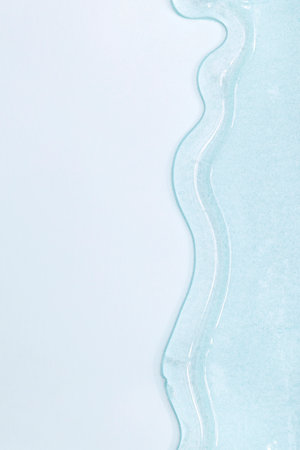 viscous pure transparent cosmetic gel on blue background. tactile, skincare, cosmetics concept. flow soft texture. element for advertising, designの写真素材