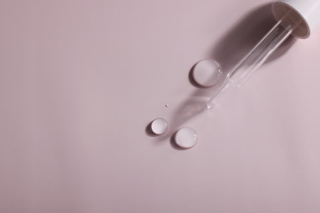dense liquid, dripping, flowing, skincare concept. Cosmetic pipette with drops of serum, vitamin or...