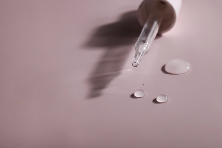 dense liquid, dripping, flowing, skincare concept. Cosmetic pipette with drops of serum, vitamin or...
