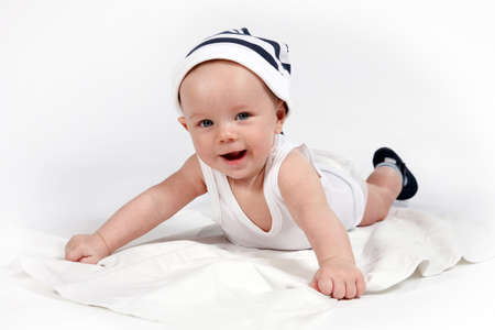 smiling baby lying in striped hatの写真素材