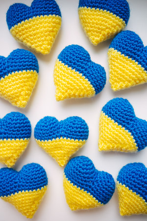 Blue and yellow knitted hearts on a white background, close-upの写真素材